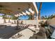Covered patio featuring a ceiling fan, built-in grill, and lush greenery in the backyard at 8012 Pottery Creek Dr, Las Vegas, NV 89128