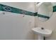 Compact half bathroom with a pedestal sink, decorative mirror, and a towel rack at 8012 Pottery Creek Dr, Las Vegas, NV 89128
