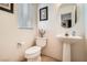 Cozy half-bathroom features a pedestal sink, toilet, and a round mirror above the sink at 8476 Tackle Box Ct, Las Vegas, NV 89113