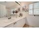 Bright bathroom with a double sink vanity, large mirror, and tiled flooring at 8476 Tackle Box Ct, Las Vegas, NV 89113
