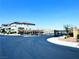 Image showcases the community entrance with black gates, desert landscaping, and views of mountains at 8694 Glen Echo Ave, Las Vegas, NV 89148