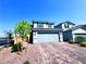 Charming two-story home with a paver driveway and a well-maintained front yard under a clear blue sky at 8694 Glen Echo Ave, Las Vegas, NV 89148