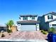 Two-story home with a two-car garage, brick driveway, manicured landscaping, and shutters at 8694 Glen Echo Ave, Las Vegas, NV 89148