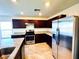 Kitchen featuring stainless steel appliances, granite countertops, and dark wood cabinets at 8694 Glen Echo Ave, Las Vegas, NV 89148