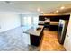 Open-concept kitchen with dark cabinets, stainless steel appliances, and a large granite island perfect for entertaining at 8694 Glen Echo Ave, Las Vegas, NV 89148