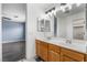Bright bathroom featuring a double sink vanity, modern lighting fixtures, and seamless transition to main bedroom at 8942 Partridge Hill St, Las Vegas, NV 89148