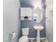 Powder room boasts a pedestal sink, oval mirror, and modern lighting for a stylish and functional space at 8942 Partridge Hill St, Las Vegas, NV 89148