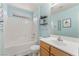 This bathroom features a vanity and a shower-tub combo with white tile surround at 8942 Partridge Hill St, Las Vegas, NV 89148