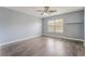 This bright bedroom features wood-look flooring, a ceiling fan, and a window offering ample natural light at 8942 Partridge Hill St, Las Vegas, NV 89148