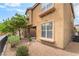 Exterior shot of the townhome with rock landscaping, a tree, and a covered parking area at 8942 Partridge Hill St, Las Vegas, NV 89148