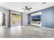 Bright living room featuring a ceiling fan, tile floors, TV, and sliding glass door to the backyard at 8942 Partridge Hill St, Las Vegas, NV 89148