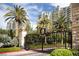 Exclusive community entrance featuring ornate gates, lush landscaping, and luxury high-rise buildings in the background at 9101 Alta Dr # 207, Las Vegas, NV 89145