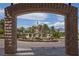 Stunning stone archway frames a beautiful fountain, lush landscaping, and mountain views at 9101 Alta Dr # 207, Las Vegas, NV 89145