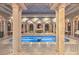 Opulent indoor pool featuring stone pillars, intricate tilework, and arched alcoves with greenery and a statue centerpiece at 9101 Alta Dr # 207, Las Vegas, NV 89145
