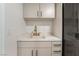 Bright laundry room features modern cabinets, quartz countertop, stainless steel faucet, and stacked washer and dryer at 9101 Alta Dr # 207, Las Vegas, NV 89145