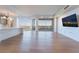 Bright living space with floor to ceiling windows, a modern kitchen, wood floors, and a large screen television at 9101 Alta Dr # 207, Las Vegas, NV 89145