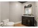 Stylish powder room with a dark vanity, marble countertop, gold accents, and elegant wallpaper at 9101 Alta Dr # 207, Las Vegas, NV 89145