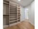 Well-organized walk-in closet with built-in shelving and hanging racks with hardwood floors at 9101 Alta Dr # 207, Las Vegas, NV 89145
