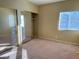 Neutral bedroom featuring carpeted floors, a mirrored closet, and a window for natural light at 9470 Peace Way # 233, Las Vegas, NV 89147