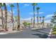 Gated community entrance with palm trees lining the drive and well-maintained landscaping at 9470 Peace Way # 233, Las Vegas, NV 89147