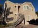 Exterior view of a building with stucco siding, staircase, and a terra cotta tiled roof under a clear blue sky at 9470 Peace Way # 233, Las Vegas, NV 89147