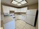 Bright, functional kitchen features white cabinets, appliances, and tile flooring at 9470 Peace Way # 233, Las Vegas, NV 89147