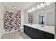 Bathroom featuring a shower-tub combo with tiled surround, and double vanity with black cabinets at 9830 Wild Coyote Ct, Las Vegas, NV 89141