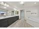 Bright bathroom featuring double sinks, a soaking tub, and a large mirror at 9830 Wild Coyote Ct, Las Vegas, NV 89141