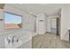 Bathroom featuring a soaking tub, a walk-in shower, and a large window at 9830 Wild Coyote Ct, Las Vegas, NV 89141