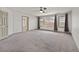 Spacious bedroom with neutral carpet, a ceiling fan, and natural light at 9830 Wild Coyote Ct, Las Vegas, NV 89141
