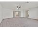 Large, carpeted bedroom featuring multiple doorways and a ceiling fan at 9830 Wild Coyote Ct, Las Vegas, NV 89141