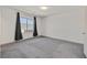 This bedroom features neutral carpet, a large window, and a minimalist aesthetic at 9830 Wild Coyote Ct, Las Vegas, NV 89141