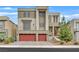Modern two-story home boasts a red two-car garage, balcony, and contemporary design at 9830 Wild Coyote Ct, Las Vegas, NV 89141