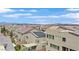 View of neighboring rooftops showcasing a community setting, some with solar panels for energy efficiency under a bright sky at 9830 Wild Coyote Ct, Las Vegas, NV 89141