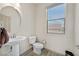 Clean half bathroom featuring a pedestal sink and natural light from a window at 9830 Wild Coyote Ct, Las Vegas, NV 89141