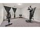 This fitness room is complete with exercise equipment, soft carpet, and a bright window at 9830 Wild Coyote Ct, Las Vegas, NV 89141