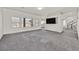 Spacious living area features neutral carpet, modern lighting, and a large window at 9830 Wild Coyote Ct, Las Vegas, NV 89141