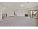 Expansive, light-filled living area with neutral carpet, ideal for entertaining and relaxation, and access to outdoor space at 9830 Wild Coyote Ct, Las Vegas, NV 89141