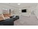 Comfortable living room with a modern entertainment center, a plush sofa, and ample natural light, ideal for relaxation at 9830 Wild Coyote Ct, Las Vegas, NV 89141
