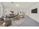 Spacious living room with gray couches, modern art, carpet, and staircase at 9830 Wild Coyote Ct, Las Vegas, NV 89141