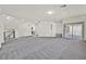 Open loft area with plush gray carpet, balcony access, and ample natural light at 9830 Wild Coyote Ct, Las Vegas, NV 89141