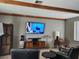 Living room with dark leather chairs, tv, decorative vase, and wood beam ceiling at 1812 Ivanhoe Way, Las Vegas, NV 89102