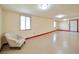 Spacious basement area with painted floors, recessed lighting, and neutral decor, plus an armchair at 9614 Orchard Oasis Ct, Las Vegas, NV 89147