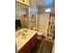Bathroom features a single vanity, shower-tub combo, and wood-look floors at 1011 Pecos River Ave, Henderson, NV 89002