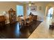 Elegant dining room with dark wood floors, formal dining set, piano, and views into the backyard at 1011 Pecos River Ave, Henderson, NV 89002