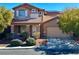 Charming two-story home boasts a tile roof, inviting front porch, manicured landscaping, and attached two car garage at 1011 Pecos River Ave, Henderson, NV 89002