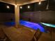 Backyard oasis featuring a pool with brilliant blue lighting, hot tub, covered patio, and outdoor dining set at 1011 Pecos River Ave, Henderson, NV 89002