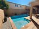 Sparkling pool features a hot tub, set in a private backyard with a covered patio, and a stone retaining wall at 1011 Pecos River Ave, Henderson, NV 89002