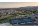 Expansive aerial view captures a community with golf courses, tennis courts, and lush landscaping amid residential homes at 10513 Shanna Trellis Ave, Las Vegas, NV 89144