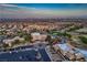 Broad aerial image displays a golf course, community buildings, and residences nestled within a landscape, set against mountain views at 10513 Shanna Trellis Ave, Las Vegas, NV 89144